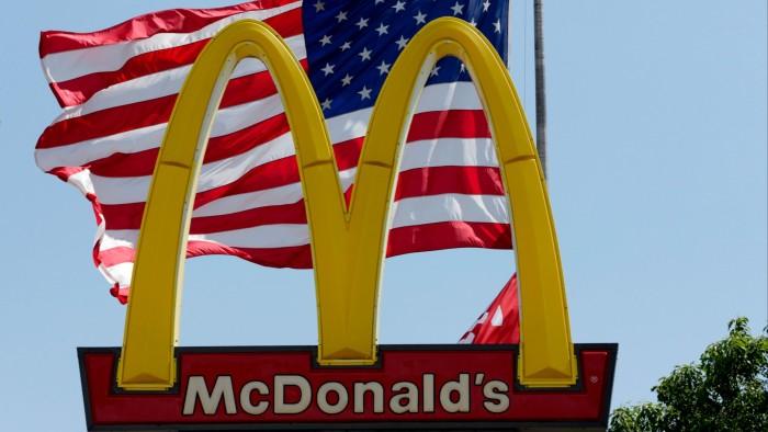 Флаг США развевается за золотыми арками ресторана McDonald's в Ла-Виста, штат Небраска.